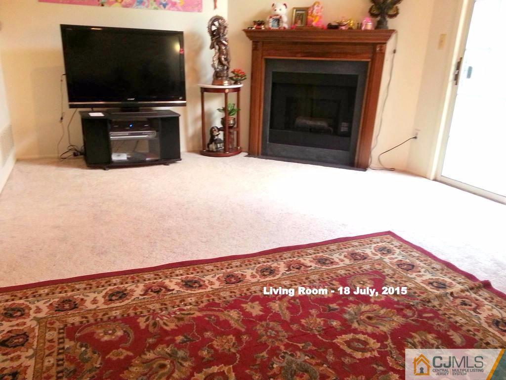 218 Nebula Road Piscataway, NJ 08854 - Photo 7 of 15 a living room with a fireplace and a flat screen tv