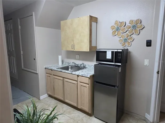a kitchen with stainless steel appliances granite countertop a refrigerator and a sink