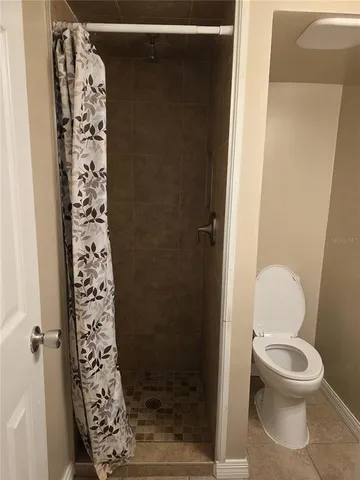 a bathroom with a toilet and a shower