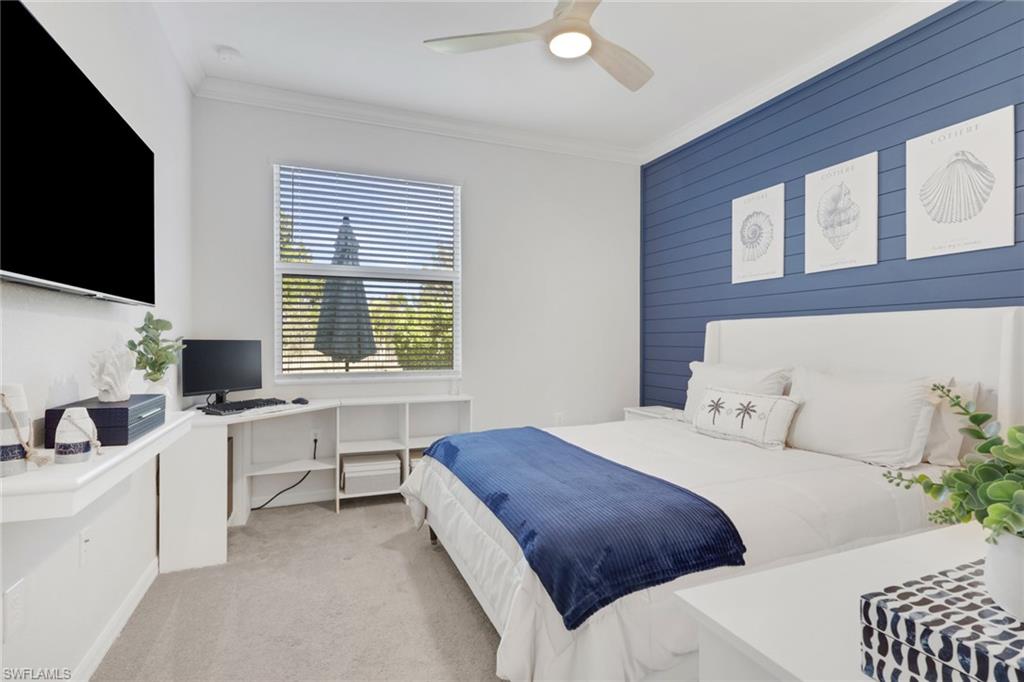 2187 Cara Cara Way Naples, FL 34120 - Photo 14 of 50 Bedroom with light carpet, a ceiling fan, wooden walls, a desk, and an accent wall