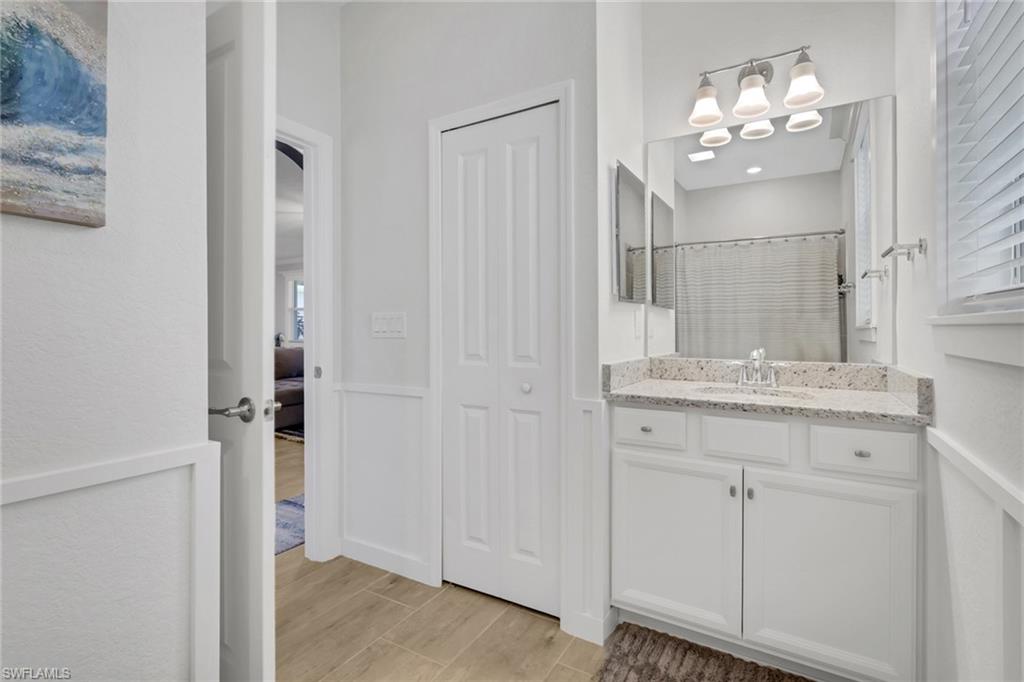 2187 Cara Cara Way Naples, FL 34120 - Photo 16 of 50 Bathroom featuring a shower with shower curtain, vanity, wood finish floors, and a closet