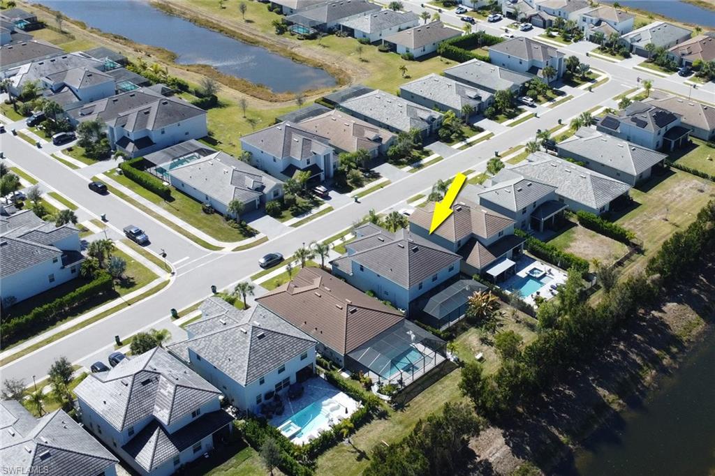 2187 Cara Cara Way Naples, FL 34120 - Photo 31 of 50 Aerial view of property and surrounding area featuring a large body of water and nearby suburban area
