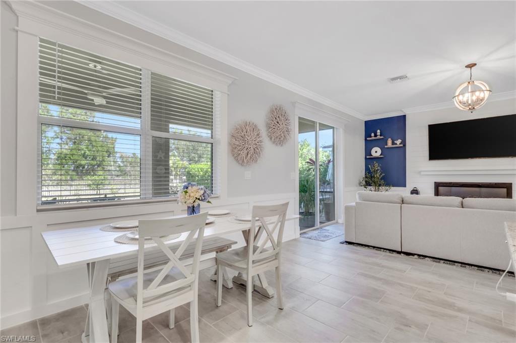 2187 Cara Cara Way Naples, FL 34120 - Photo 6 of 50 Dining space featuring a chandelier, ornamental molding, and wood tiled floors
