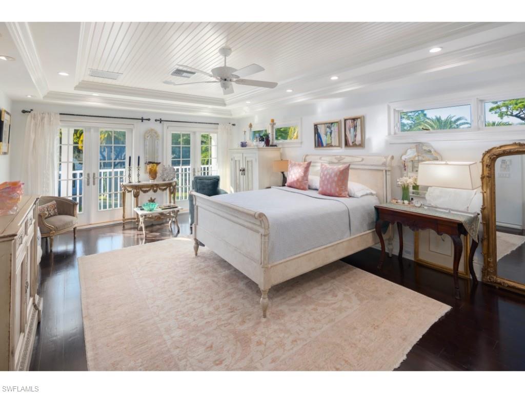 247 6th Street North Naples, FL 34102 - Photo 15 of 30 a spacious bedroom with a large bed and a wooden floor
