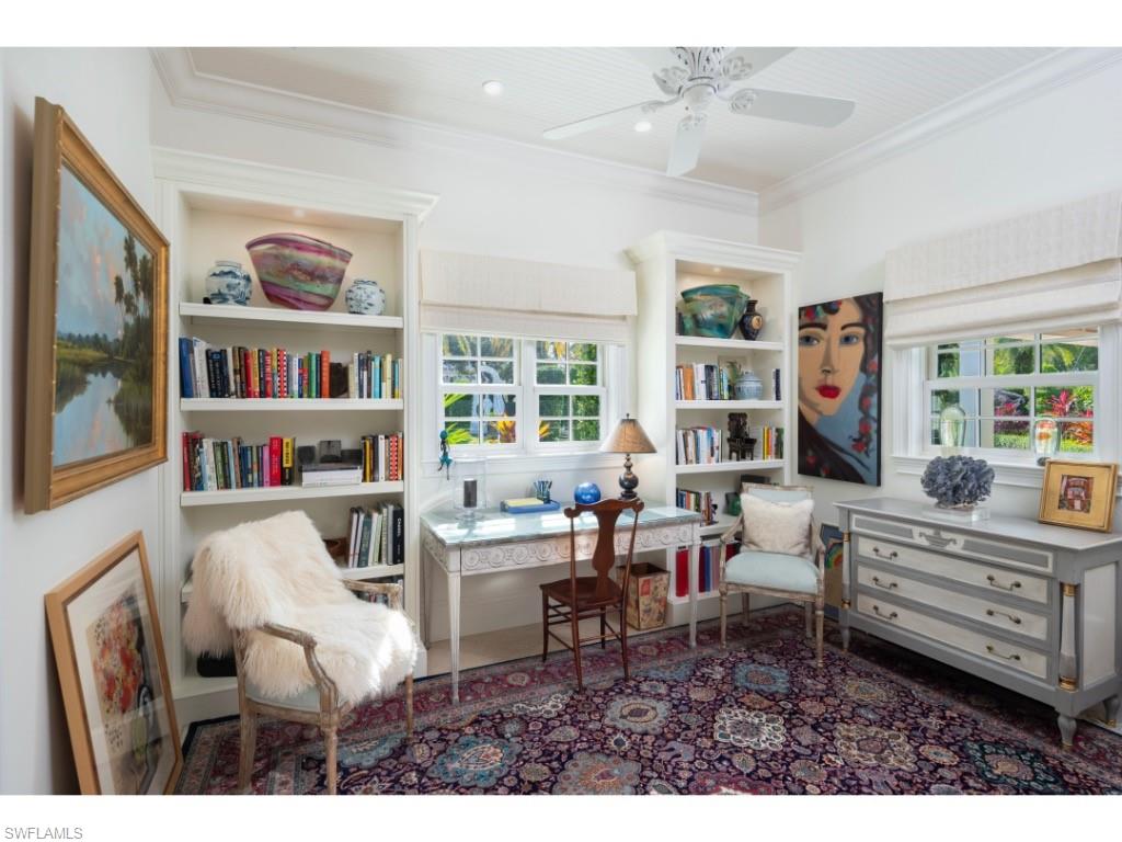 247 6th Street North Naples, FL 34102 - Photo 18 of 30 a living room with furniture a bookshelf and a window
