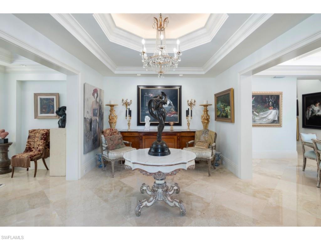 247 6th Street North Naples, FL 34102 - Photo 8 of 30 a living room with furniture a chandelier and a fireplace