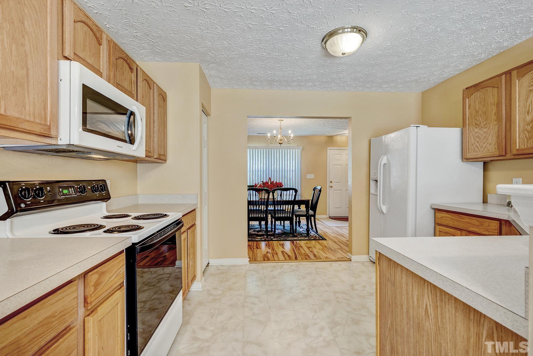 5712 Forest Point Road Raleigh, NC 27610 - Photo 11 of 23 a kitchen with stainless steel appliances granite countertop a refrigerator and a stove top oven