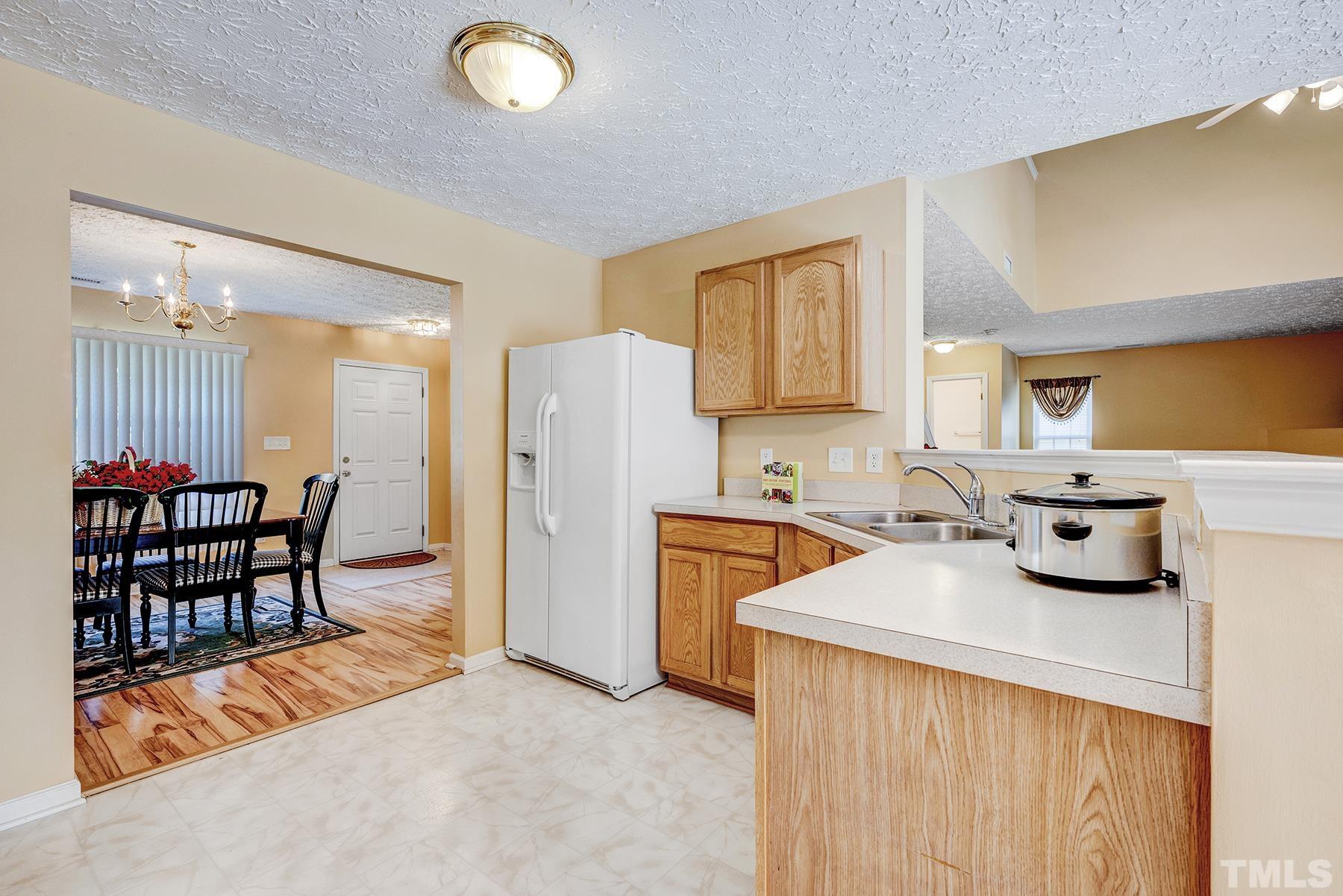 5712 Forest Point Road Raleigh, NC 27610 - Photo 12 of 23 a kitchen with stainless steel appliances granite countertop a sink a stove and a refrigerator
