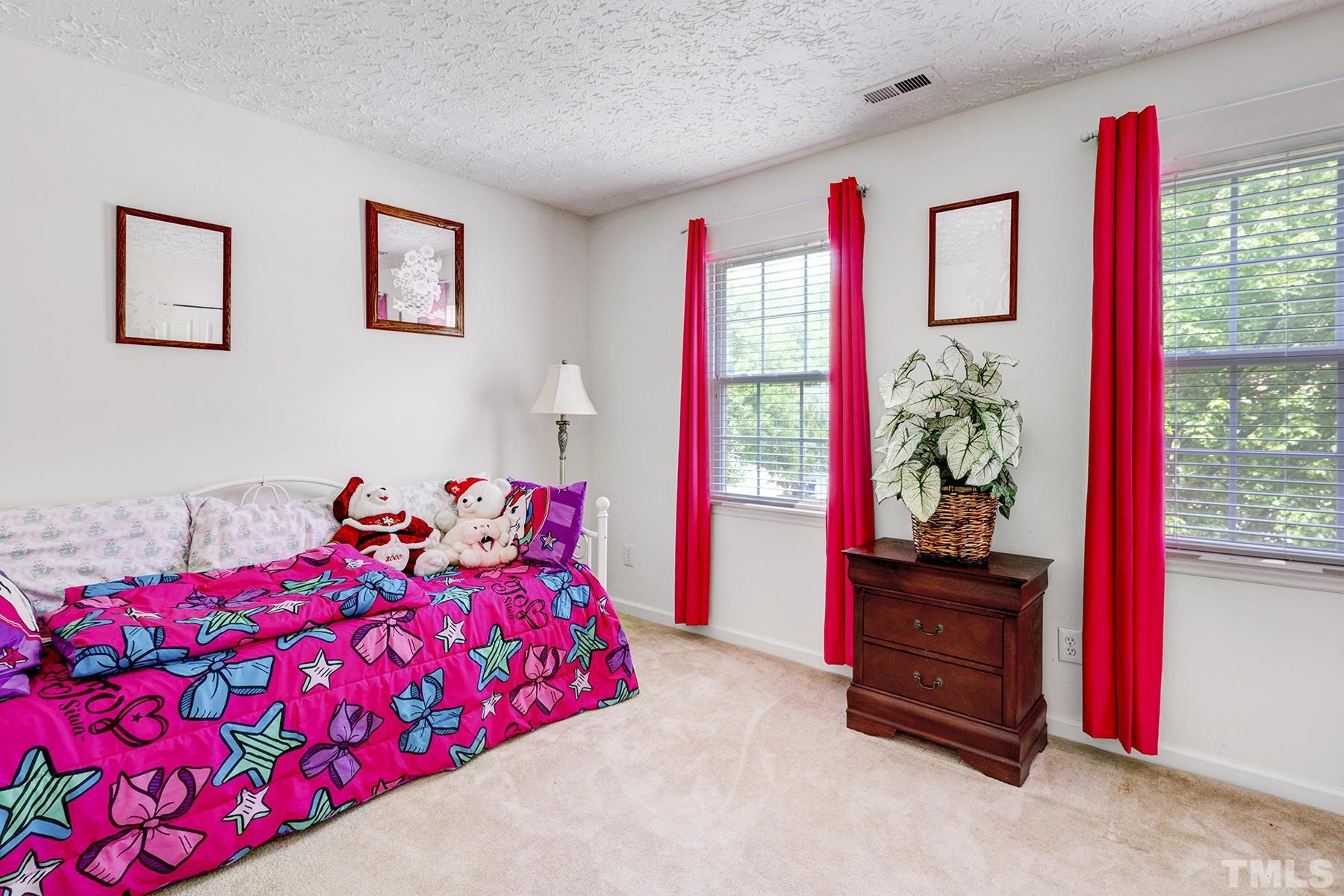 5712 Forest Point Road Raleigh, NC 27610 - Photo 18 of 23 a bedroom with a bed and a potted plant