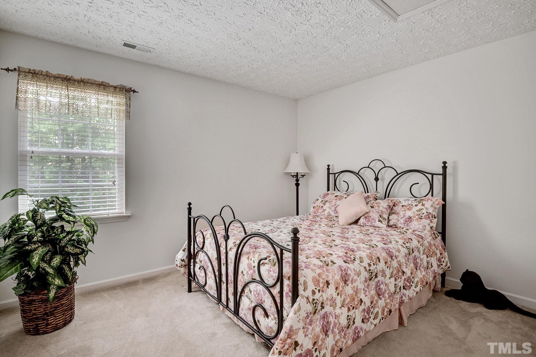 5712 Forest Point Road Raleigh, NC 27610 - Photo 22 of 23 a bedroom with a bed and a potted plant