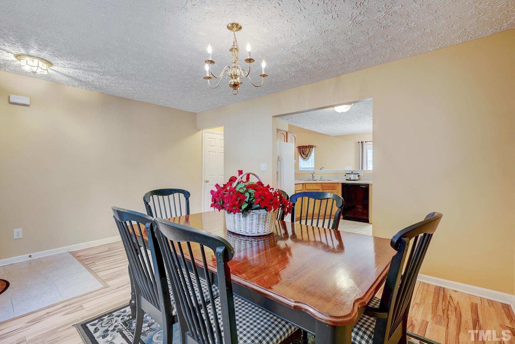 5712 Forest Point Road Raleigh, NC 27610 - Photo 7 of 23 a view of a dining room with furniture and chandelier