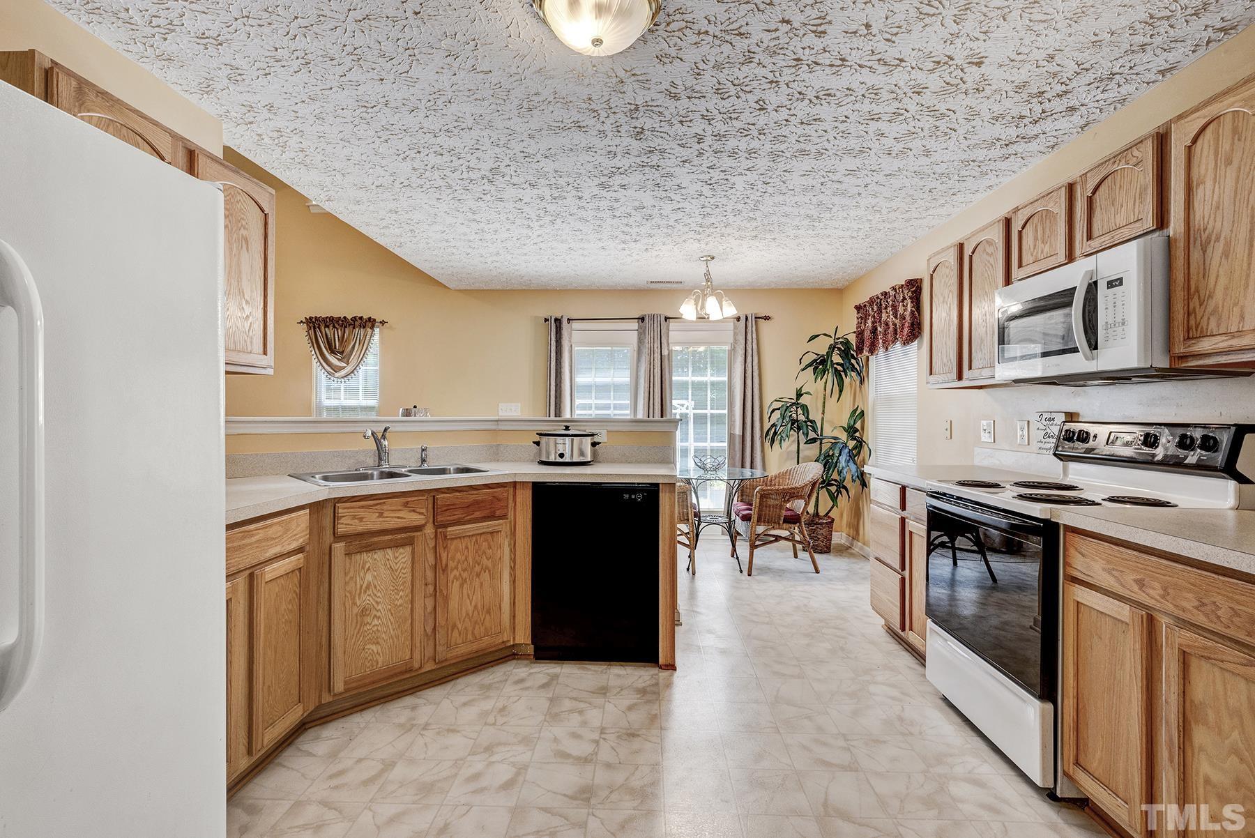 5712 Forest Point Road Raleigh, NC 27610 - Photo 8 of 23 a kitchen with stainless steel appliances granite countertop a stove and a sink