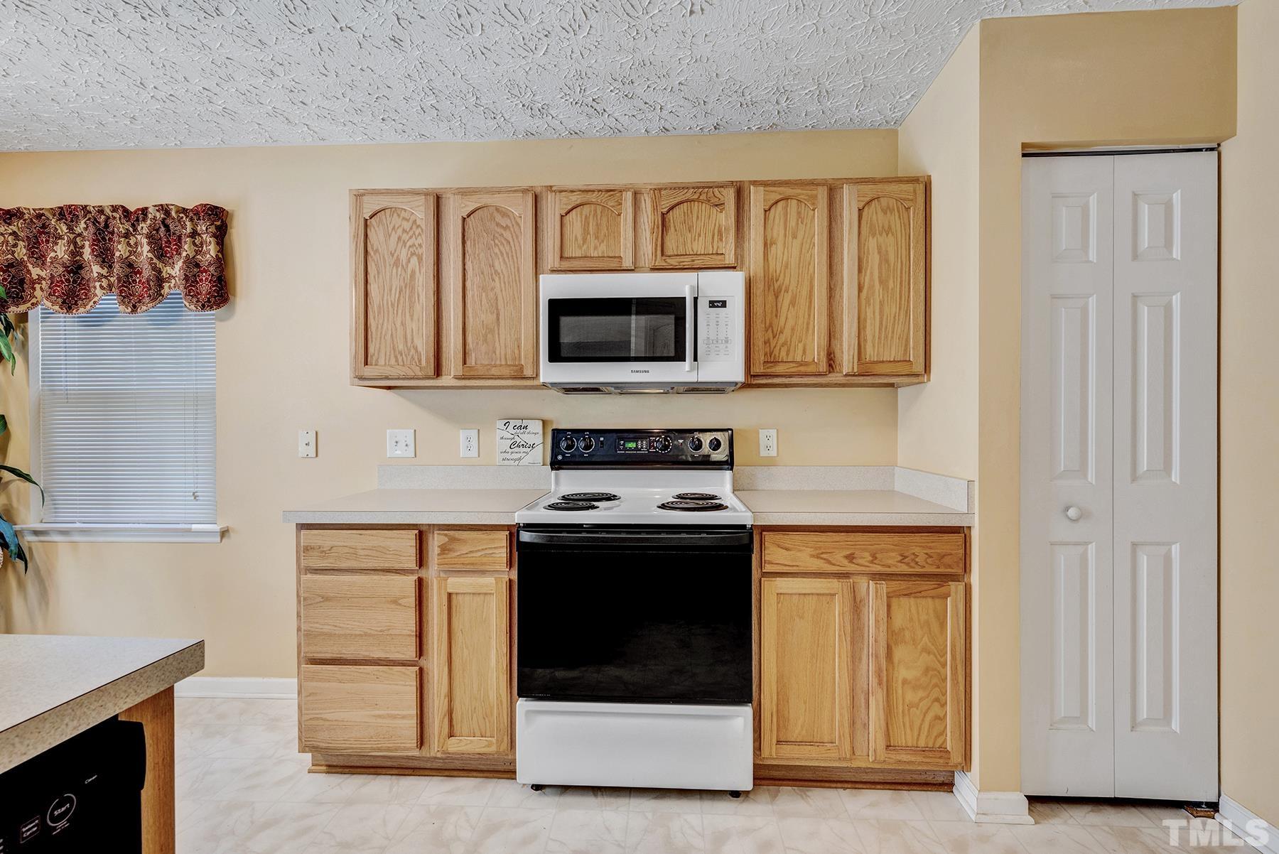 5712 Forest Point Road Raleigh, NC 27610 - Photo 9 of 23 a kitchen with stainless steel appliances granite countertop a stove and a microwave