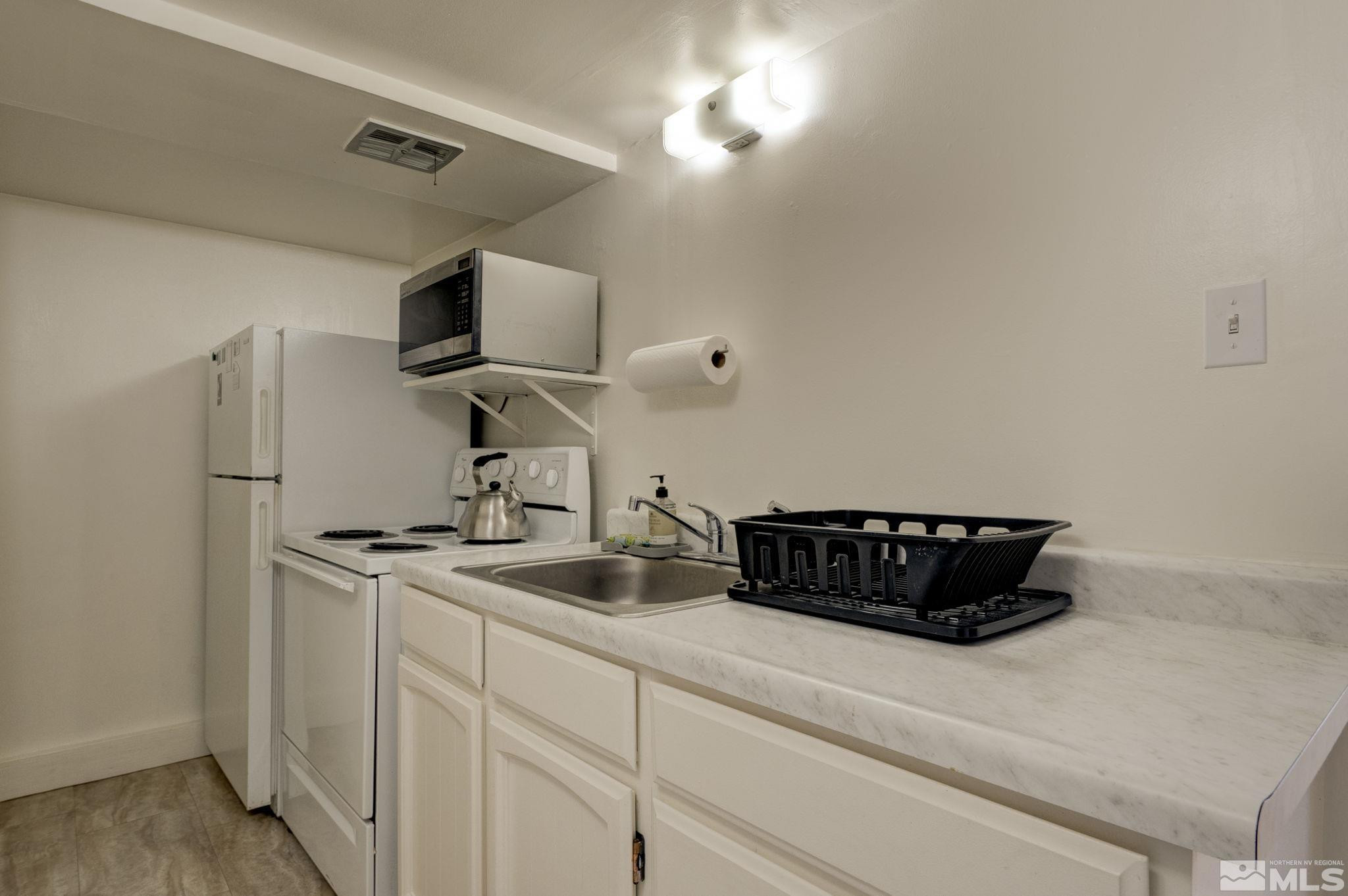 1102 Codel Way Reno, NV 89503 - Photo 23 of 33 a kitchen with a sink a stove and a refrigerator