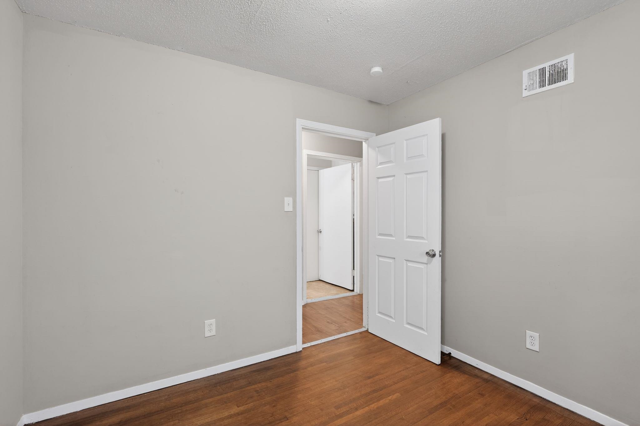 4314 Ford Road Memphis, TN 38109 - Photo 9 of 31 Unfurnished bedroom with dark wood finished floors and a textured ceiling