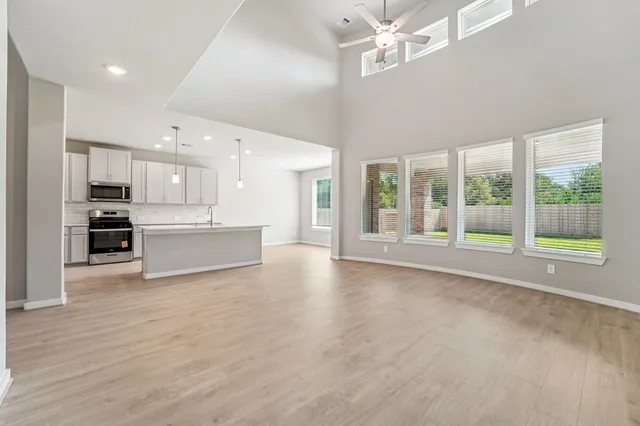 a view of an empty room with kitchen appliances and a kitchen view