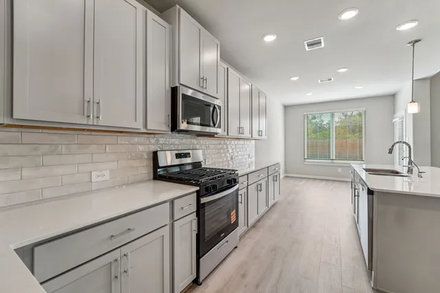 a kitchen with stainless steel appliances granite countertop a sink stove and refrigerator