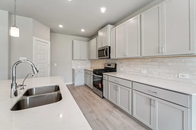 a kitchen with sink a microwave and cabinets