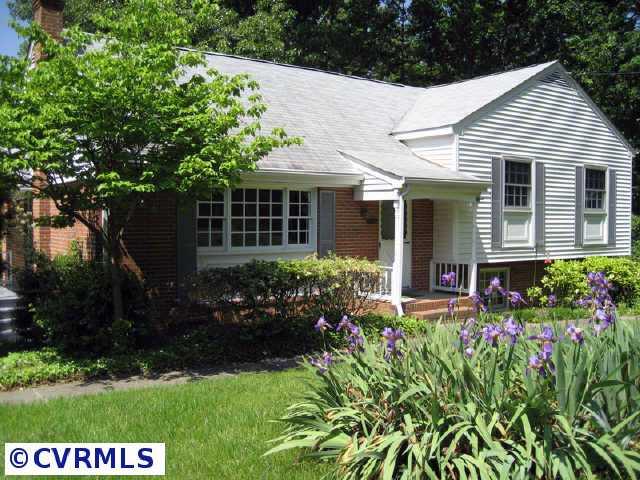a front view of a house with a yard and potted plants