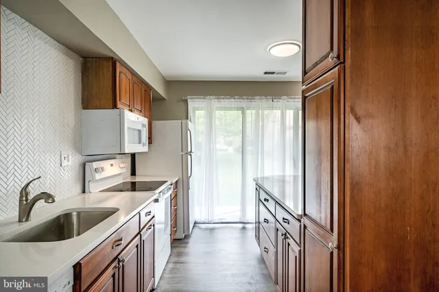 a kitchen with stainless steel appliances a refrigerator and wooden cabinets