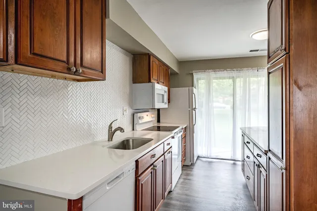 a kitchen with stainless steel appliances granite countertop a sink and a refrigerator