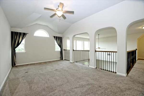 an empty room with windows and fan