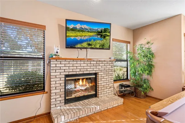 a view of a dining room with furniture a chandelier and wooden floor