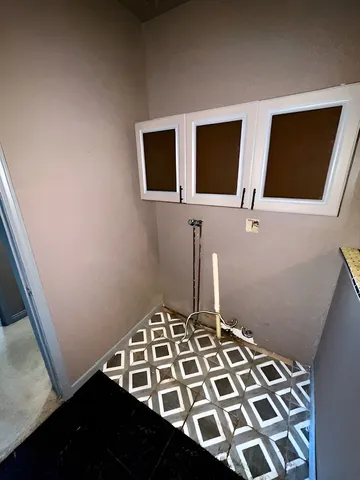 a room with water heater and cabinets