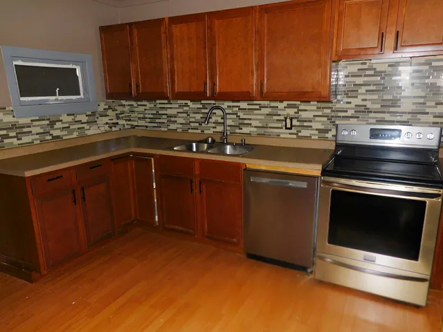 a kitchen with stainless steel appliances granite countertop a stove a sink and a refrigerator