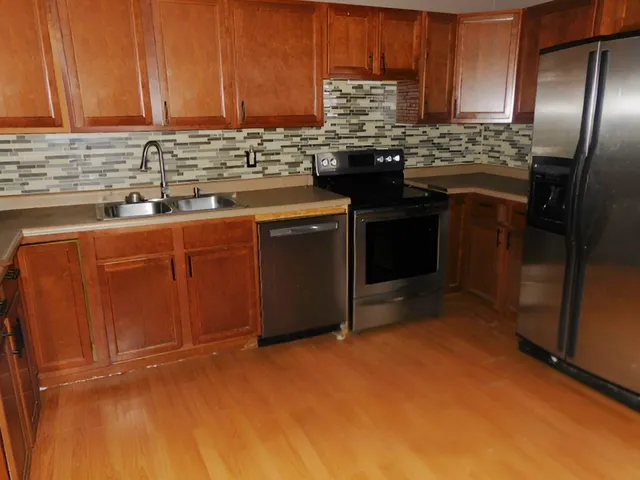an empty room with a window and a chandelier fan