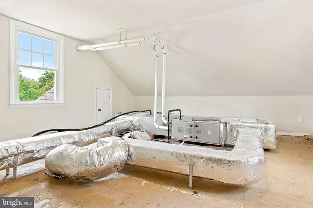 a bed sitting in a bedroom next to a window and a larger closet