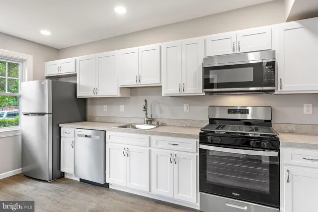 a kitchen with white cabinets and stainless steel appliances