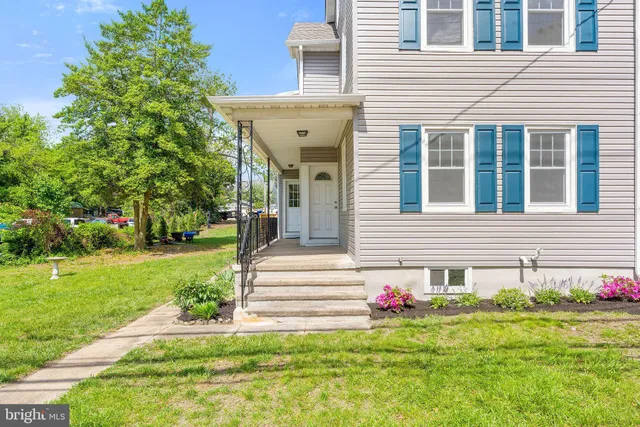 a front view of a house with a yard and trees