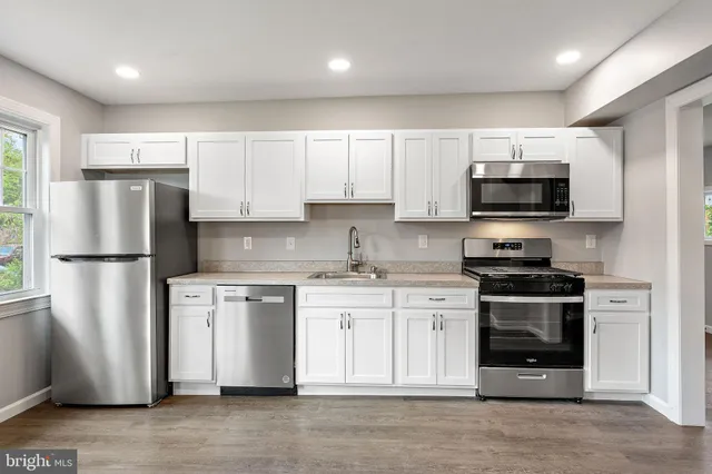 a kitchen with stainless steel appliances granite countertop a refrigerator stove a sink and a microwave