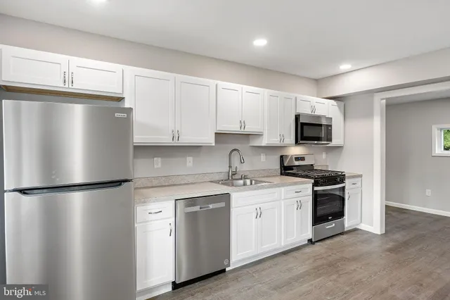 a kitchen with a refrigerator sink and cabinets