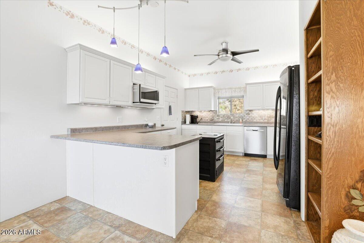 1980 Koch Ranch Road Cornville, AZ 86325 - Photo 11 of 41 a kitchen with kitchen island a sink stainless steel appliances and white cabinets