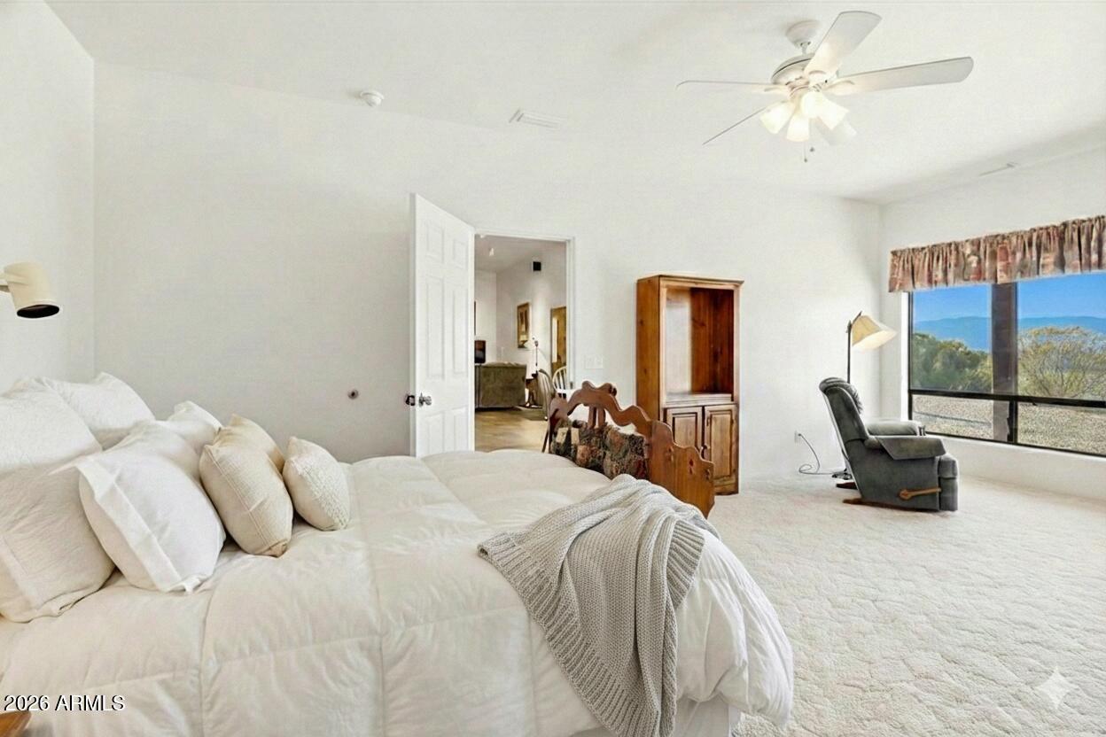 1980 Koch Ranch Road Cornville, AZ 86325 - Photo 13 of 41 a bed room with a bed a couch and a chandelier