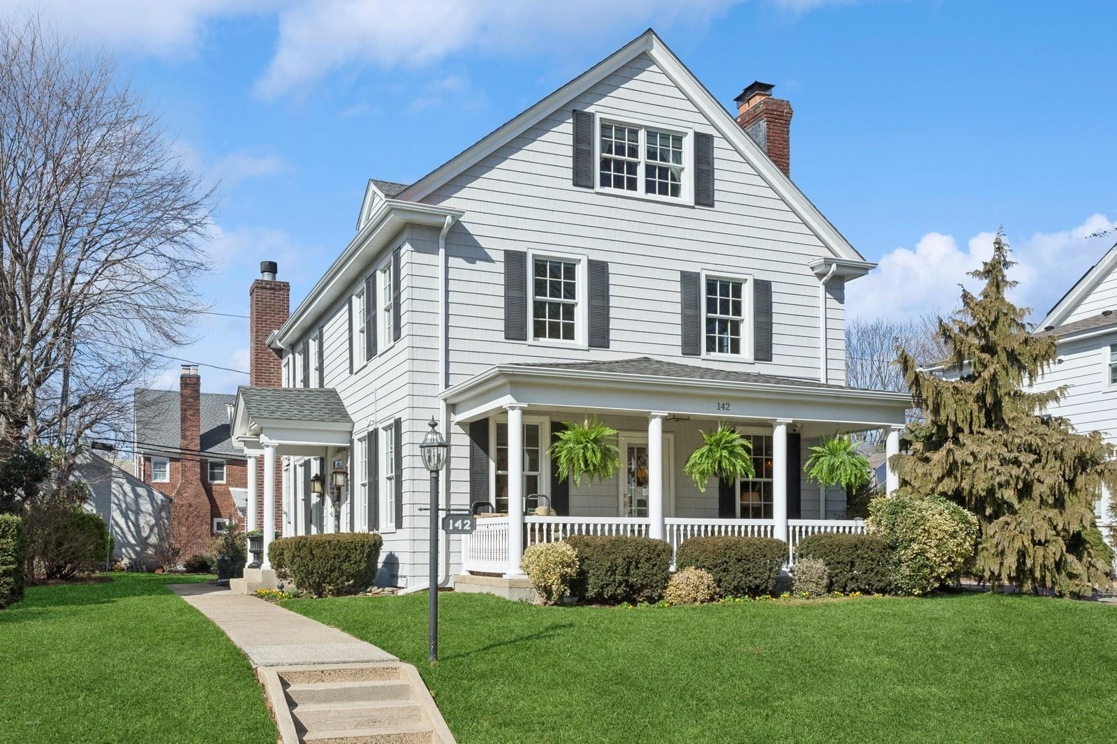 142 Roxbury Road Garden City, NY 11530 - Photo 1 of 1 a front view of a house with garden and plants