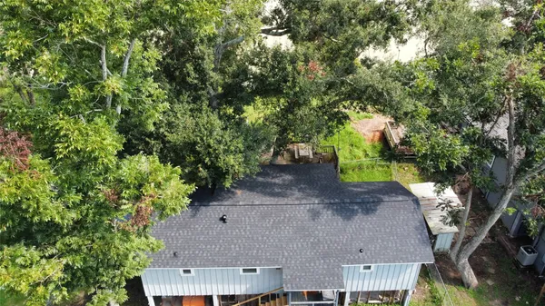 an aerial view of a house with a yard and large trees