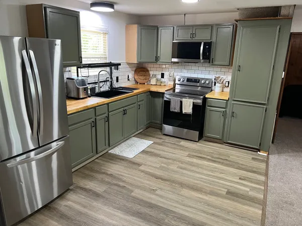 a kitchen with stainless steel appliances granite countertop a refrigerator sink and microwave