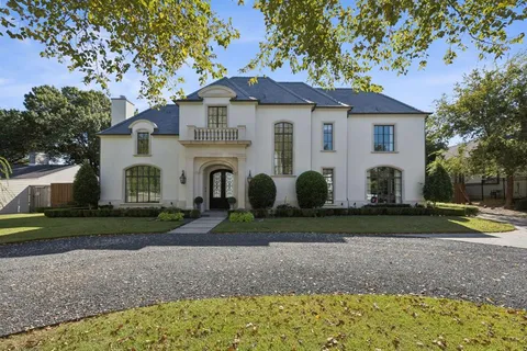 a view of a white house with a yard and plants