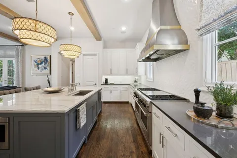 a kitchen with a kitchen island a sink appliances and cabinets