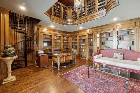 a living room with furniture a bookshelf and a large window