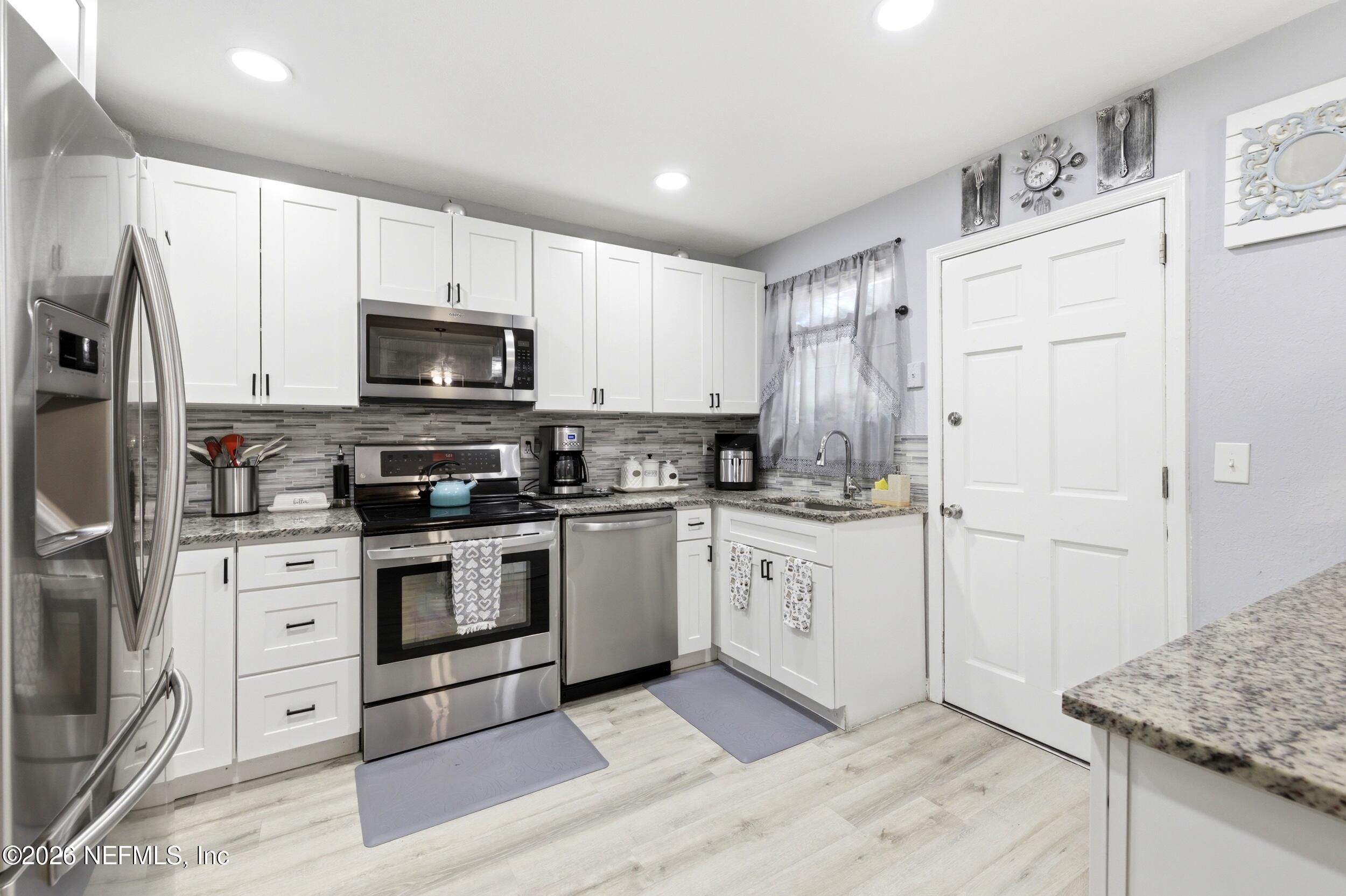 1955 Layton Road Jacksonville, FL 32211 - Photo 13 of 35 a kitchen with granite countertop white cabinets and stainless steel appliances