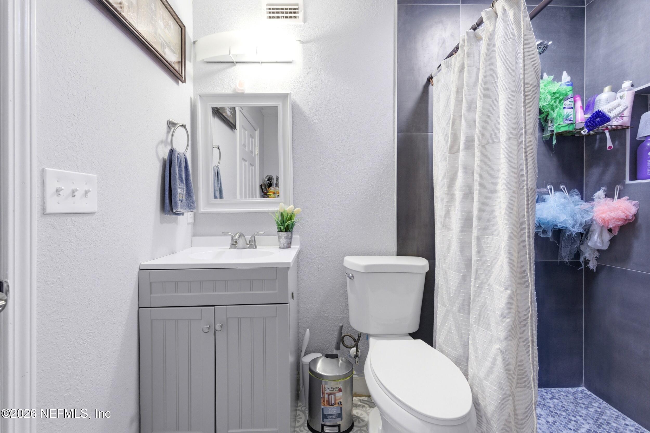 1955 Layton Road Jacksonville, FL 32211 - Photo 22 of 35 a bathroom with a toilet a sink and mirror