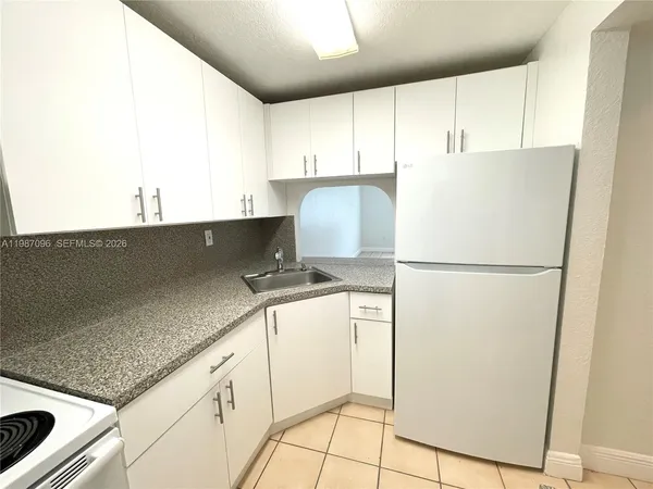 a kitchen with appliances a sink and a refrigerator