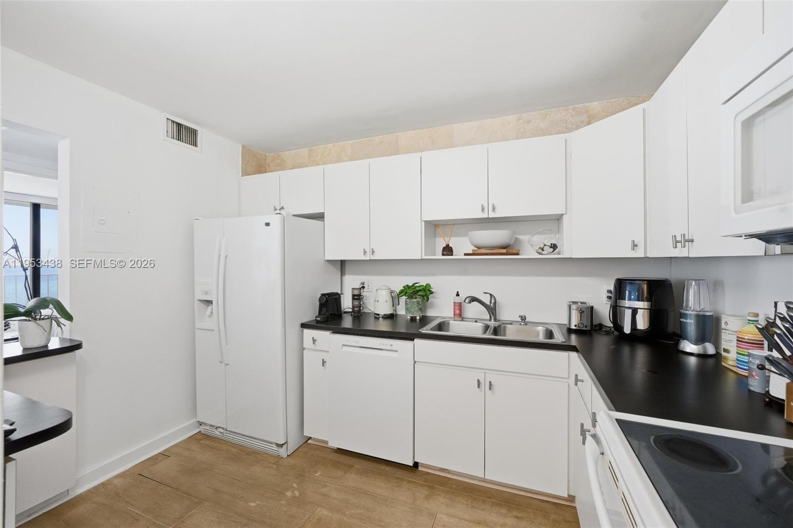200 Southeast 15th Road, Unit 11H Miami, FL 33129 - Photo 14 of 25 a kitchen with stainless steel appliances granite countertop a refrigerator sink and white cabinets