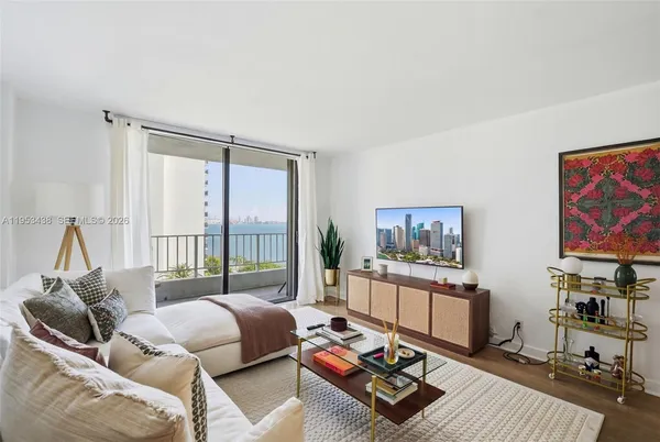 a living room with furniture large window and a flat screen tv