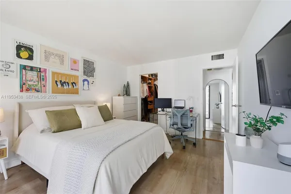 a bedroom with bed and a flat screen tv