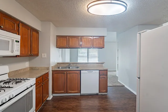 a kitchen with stainless steel appliances granite countertop a stove a sink and a microwave